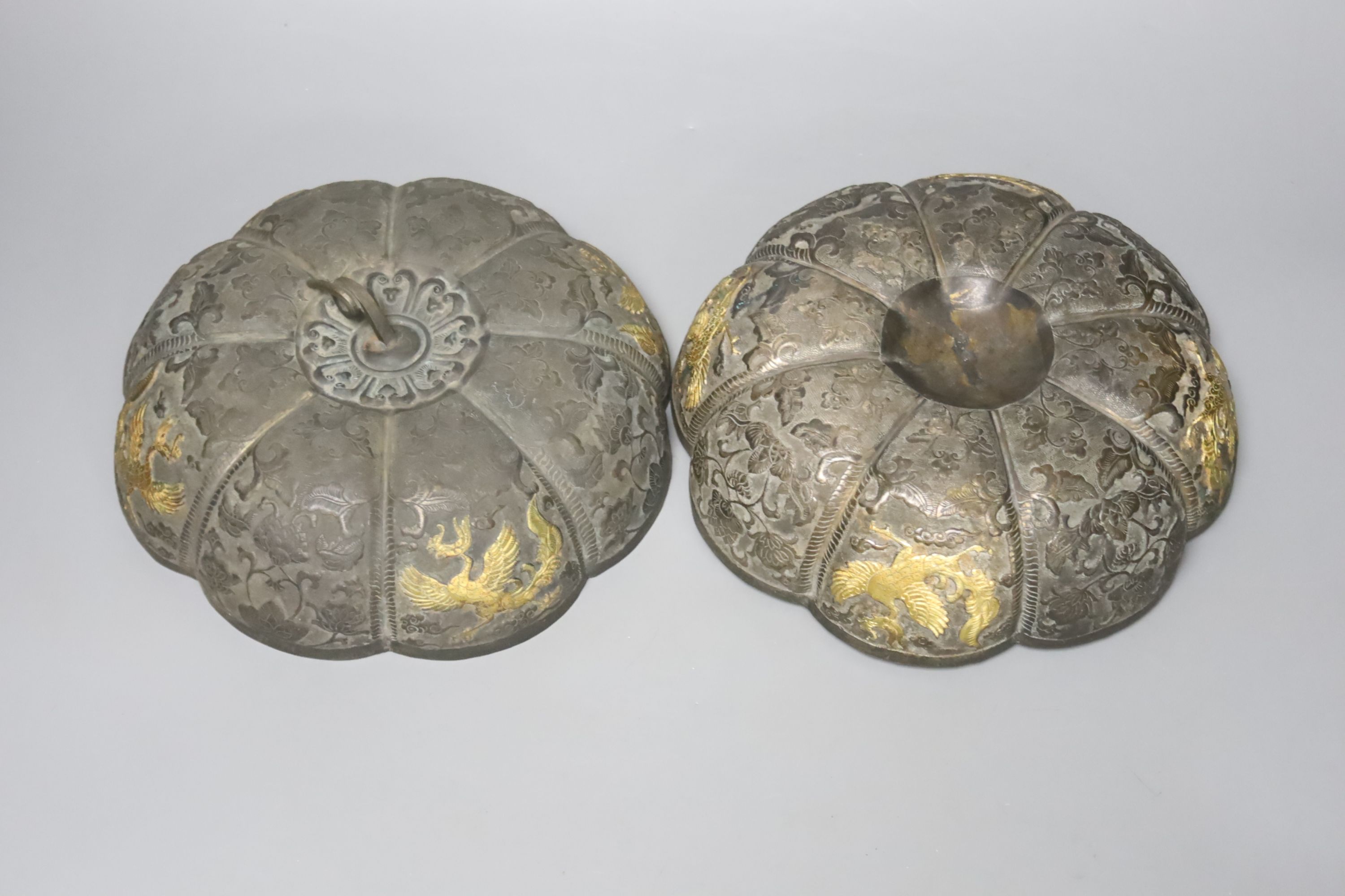 A 19th century Chinese melon-shaped silvered bronze box and cover, applied with gold figures of dragons in flight, Tang dynasty or later, 19cm diameter 10cm high